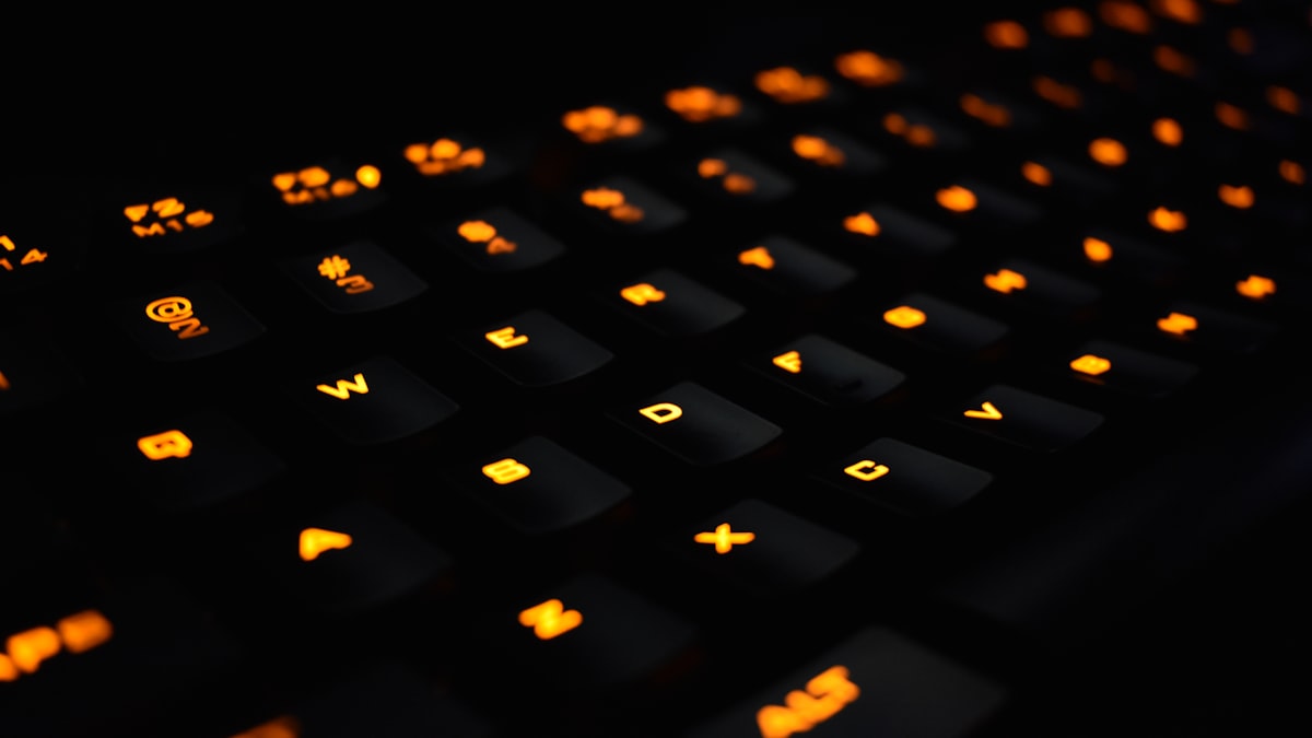 Primer plano de un teclado mecánico gaming con retroiluminación en tonos cálidos